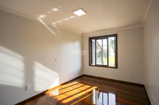 Sala de estar com piso de madeira e luz natural entrando pela janela.