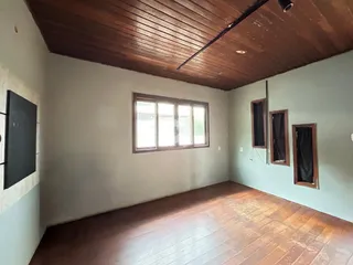 Sala de estar com piso de madeira e teto de tábuas de madeira.