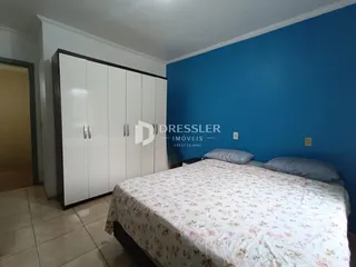 Quarto com armário e cama em parede azul.