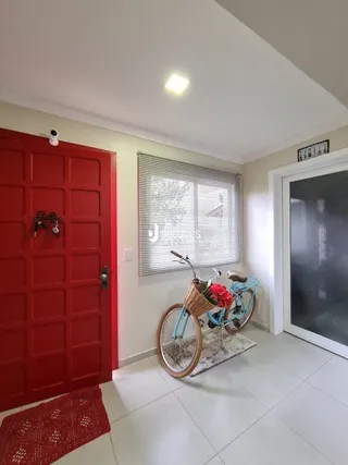 Interior de um corredor com portas vermelhas e piso branco.