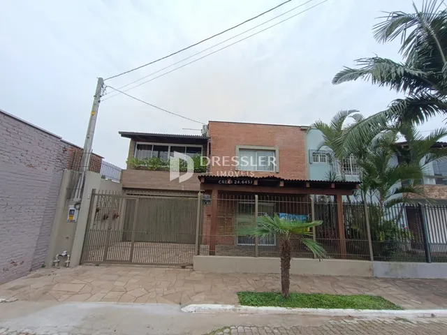 Fachada de uma residência em Lajeado, Brasil, com cerca e portão de ferro.