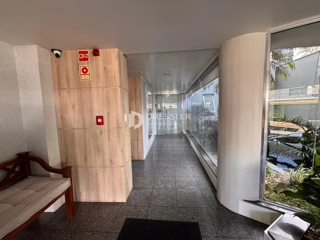 Hall de passagem interno com revestimento de madeira e piso cerâmico.