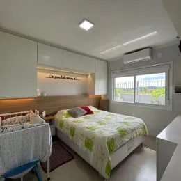 Quarto com cama e armários brancos.