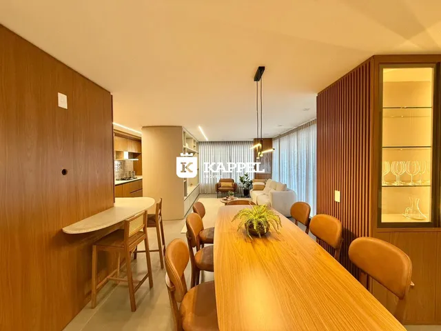 Uma sala de jantar com mesa de madeira e cadeiras em um apartamento.