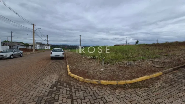 Vista da propriedade com área gramada e calçada no entorno.