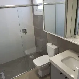 Foto de um banheiro mostrando um vaso sanitário e uma pia brancos.