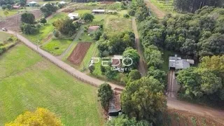 Vista aérea de terras agrícolas e vegetação em uma área rural.