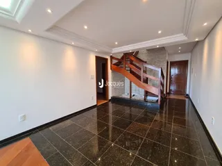 Hall de entrada com piso de cerâmica escura e escadaria de madeira.
