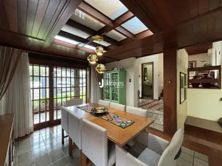 Vista interna de uma sala de jantar com piso de cerâmica e tetos de madeira.