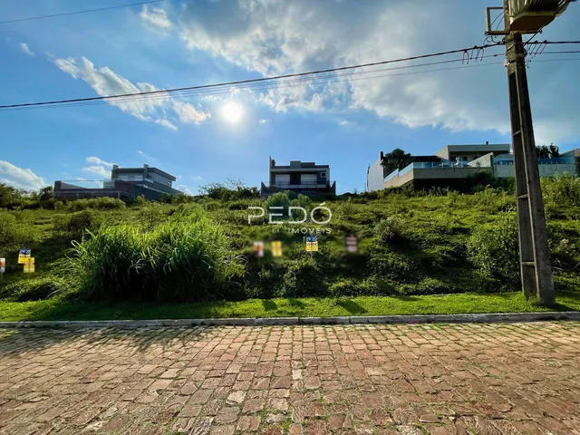 Vista externa de uma propriedade com vegetação densa ao fundo.