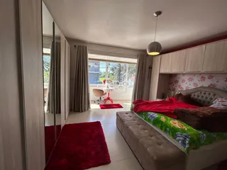 Quarto com cama e sofá em ambiente claro.