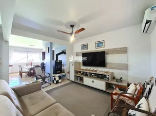 Sala de estar com sofá e televisão em um imóvel no Brasil.