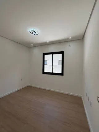 Ambiente interno com piso de madeira e janela em um imóvel.
