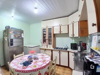 Foto de uma cozinha com armários brancos e mesa de jantar.