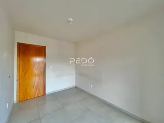 Hall de entrada com porta de madeira e piso de cerâmica cinza.