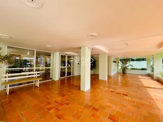 Ambiente interno amplo com piso de tijolos vermelhos.
