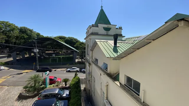 Fachada de uma residência em Lajeado, Brasil, com telhado verde e paisagismo frontal.