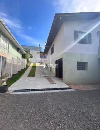 Vista da fachada de uma residência em Lajeado, Brasil, com um pátio pavimentado.