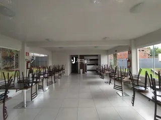 Uma sala ampla com cadeiras alinhadas no interior da propriedade.