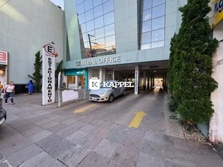Exterior de um prédio comercial moderno em Lajeado, Brasil, mostrando a entrada e área de estacionamento.