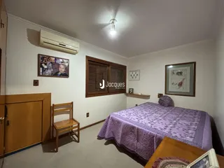 Quarto interno com cama e armário de madeira em Lajeado.