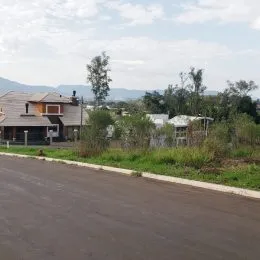 Foto da rua em frente à propriedade com vegetação ao fundo.
