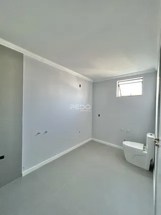 Foto de um ambiente interno com paredes cinzas e piso claro.