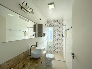 Foto de um banheiro moderno com revestimento de azulejos brancos e detalhes em padrão.