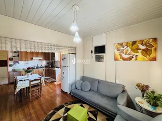 Sala de estar com cozinha e sala de jantar em um imóvel.