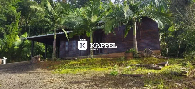 Fachada de uma casa de madeira em um ambiente com vegetação densa.