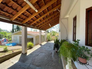 Vista da fachada de uma residência com estrutura de madeira e área externa.