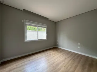Foto de um cômodo interno com piso de madeira e uma janela.