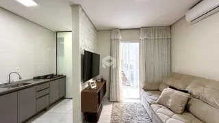 Sala de estar com sofá e área de cozinha visível.