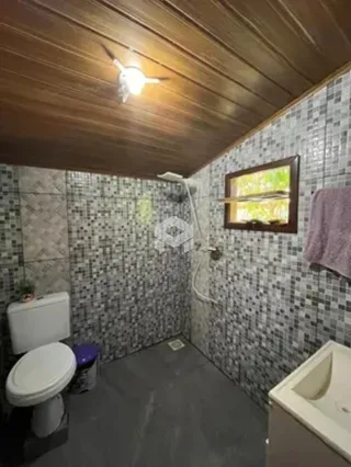 Foto de um banheiro com revestimento de azulejos cinzentos.