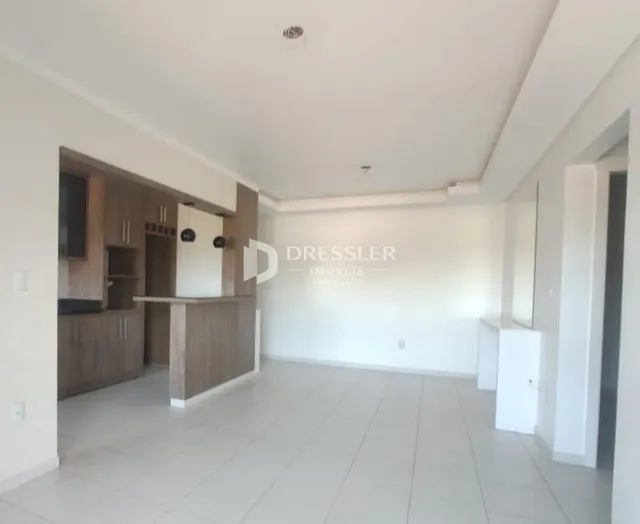 Ambiente interno de uma sala de estar com piso claro e armários de madeira.