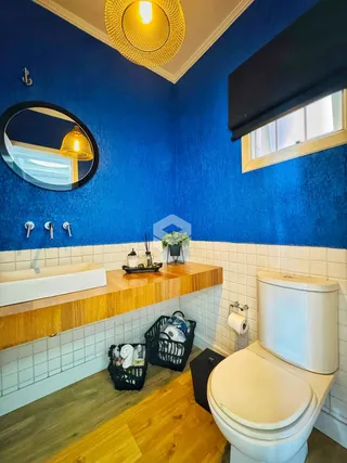Foto de um banheiro com paredes azuis e revestimento de azulejos brancos.