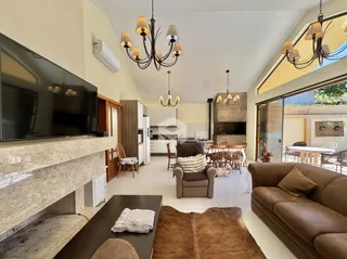 Sala de estar com vista para a área externa e cozinha integrada.
