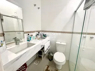 Foto de um banheiro com pia, vaso sanitário e box de vidro.