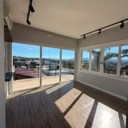 Sala de estar com grandes janelas oferecendo uma vista panorâmica.