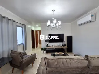 Sala de estar com sofá e televisão em um ambiente claro.