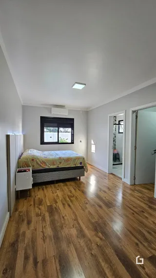 Quarto com piso de madeira e janela em um imóvel em Lajeado.