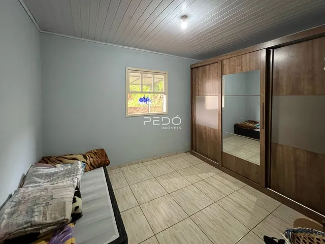 Quarto com piso de cerâmica e armário de madeira em imóvel no Brasil.