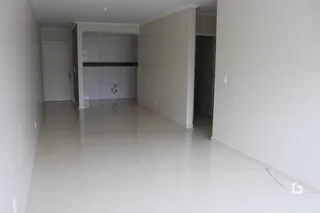 Hall de entrada com piso claro e paredes brancas.