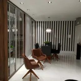 Hall de entrada com paredes listradas pretas e brancas e portas de vidro.