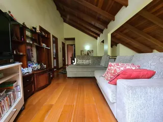 Sala de estar com piso de madeira e paredes claras em uma residência.