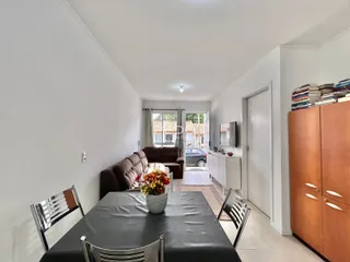 Sala de estar com sofá e mesa de jantar em um apartamento.