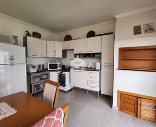 Foto de uma cozinha com armários brancos e piso de cerâmica.