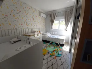 Quarto com parede estampada e cama visível.