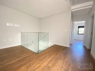Ambiente interno com piso de madeira e divisória de vidro.