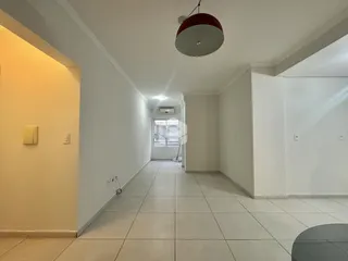 Vista do corredor interno de uma residência com piso de cerâmica clara.